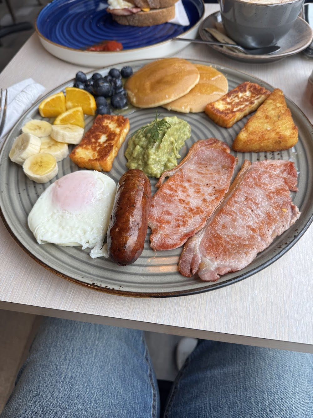 A full brunch plate at Breakfast Zone Cafe — pancakes, halloumi, bacon, sausage, banana and blueberries